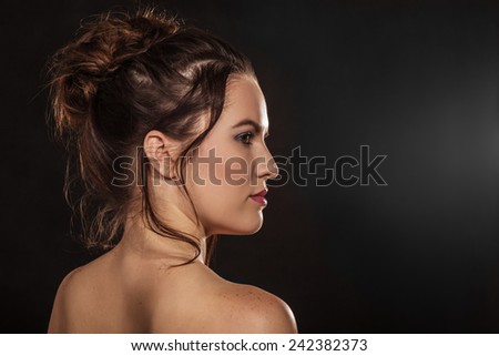 sensual young woman bare back profile in dark