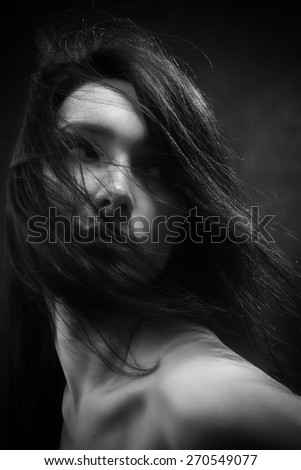 bared woman with fluffy hair looking back monochrome
