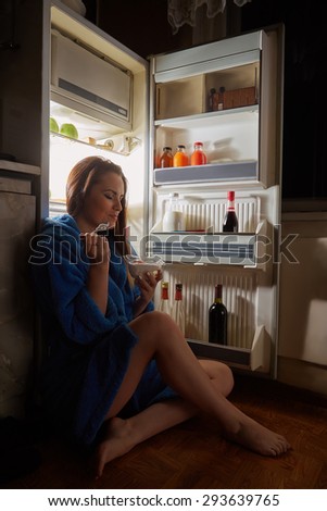 woman eating dessert near refrigerator