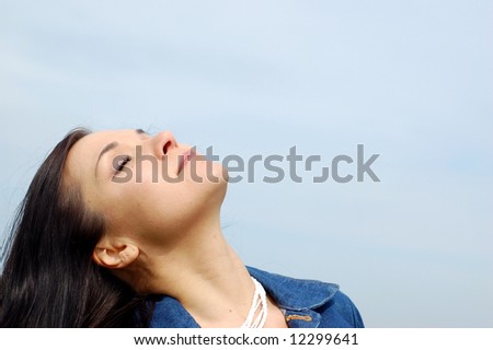 attractive brunette woman on sky background
