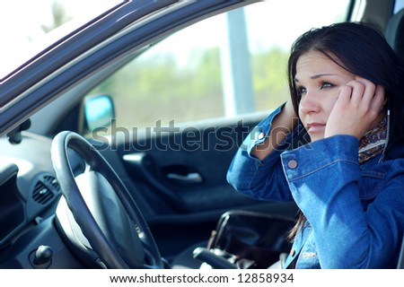 angry woman with mobile phone in her car