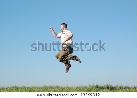 happy man jumping on green meadow