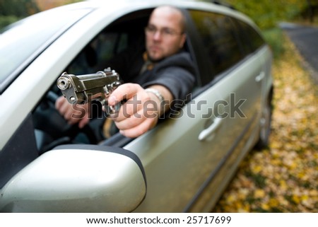 angry man with gun driving car