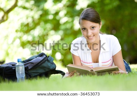 happy young woman learning in park