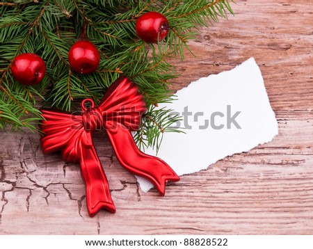 Christmas wreath made from fresh spruce branch and red ornaments on old wooden background