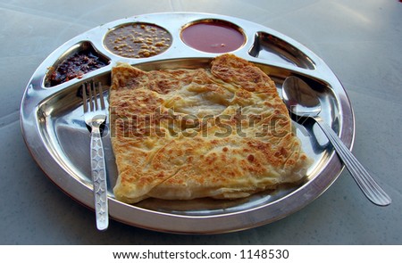 popular Malaysian pan cake eaten with curry sometime using hand