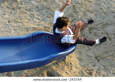 Boy at the end of slide. Blurred on purpose with shutter speed to show motion.
