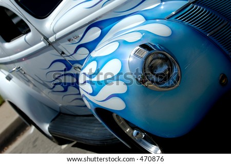 Front side of vintage car, white with blue flames paint job
