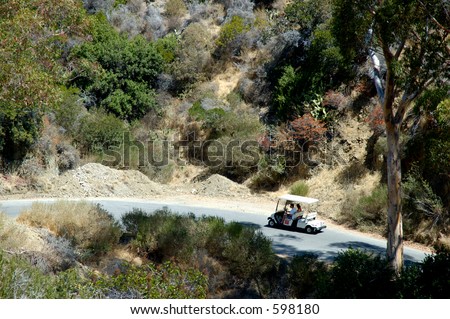Couple in electric golf cart going up a hill in Avalon, Santa Catalina Island, California.