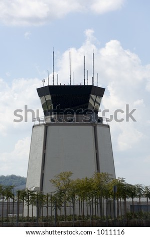 Airport traffic control tower with small airplane taking off