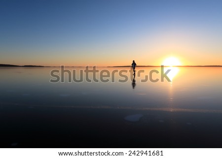 Ice skating on lake Malaren close to Vasteras, Sweden, at sunset.