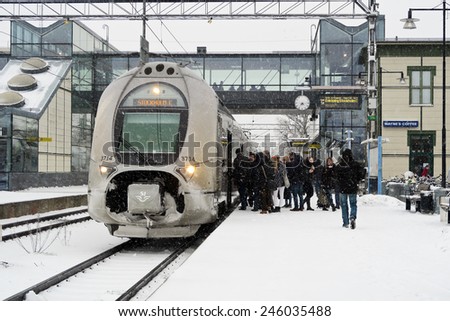 Vasteras, Sweden - January 21: Passenger board a train to capital Stockholm on a snowy winter day in the city of Vasteras on January 21, 2015 in Vasteras, Sweden.