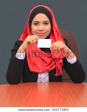 young asian muslim women smile to camera while holding white card