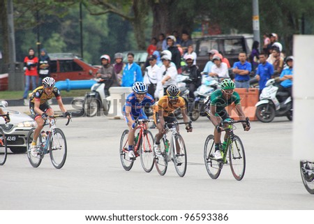 KUANTAN - MARCH 1: Unidentified cyclists take last corner during Stage 7 of the le Tour de Langkawi from Bentong to Kuantan on March 1, 2012 in Kuantan, Pahang, Malaysia.