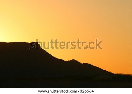 Graphic Nature: A mountain silhouette against a sunset sky. Makes a great background. Space for copy.