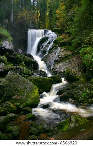 Black Forest Falls: Vertical Shot of a waterfall cascade over moss-covered rocks in the Black Forest, Tribourg, Germany.