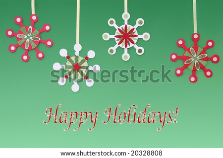 Four country-style snowflakes hang from ribbons against a gradated green background with a cheerful holiday greeting.