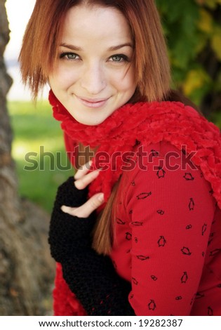 A beautiful woman with a red hair, red scarf, and red top.