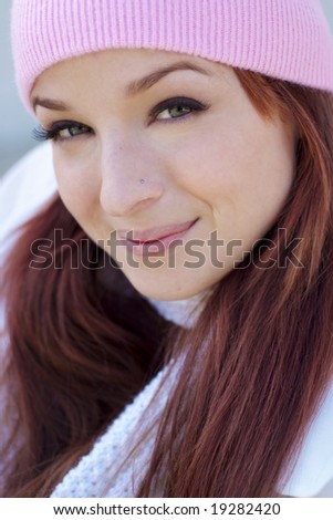 A beautiful woman with a red hair, white scarf, and pink bonnet.
