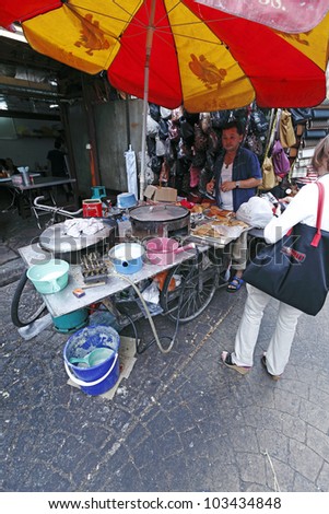 KUALA LUMPUR, MALAYSIA - MAY 18: Street food vendor at his mobile stall on May 18, 2012 in Chinatown Kuala Lumpur, Malaysia. The area is a famous flea market earmarked for demolition for a train line.