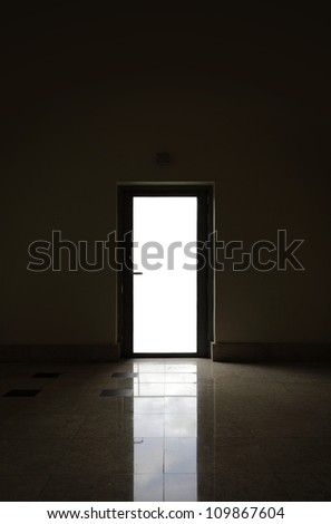 A blank space for text  on the glass pane of a metal door frame silhouette with reflection on the floor.