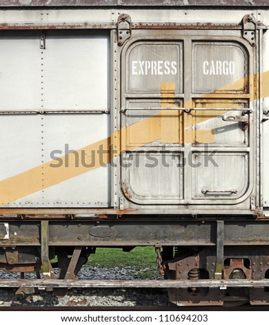 A rusty sliding metal door on the side of a freight cargo train carriage with the label Express Cargo.