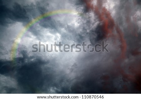 A rainbow arch in a dramatic storm cloud.