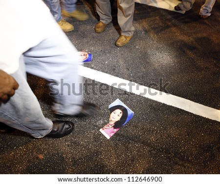 KUALA LUMPUR, MALAYSIA-AUG 30:Protester steps on Malaysia Prime Minister wife's photo at the Alliance of NGO for democracy street rally in Dataran Merdeka on August 30, 2012 in Kuala Lumpur, Malaysia.