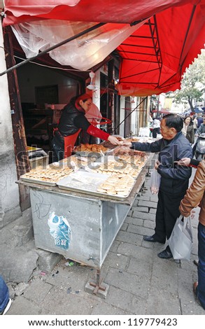 SUZHOU, CHINA - NOV 6: Shopper purchase roast sesame bun on November 6, 2012 in Shantangjie, Suzhou, China. Shantangjie is a 1100 year old historic market street build in 825 AD in the Tang Dynasty.