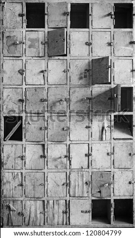 Facade of an old vintage timber postal box with locks and latch in monochrome, for textural background.