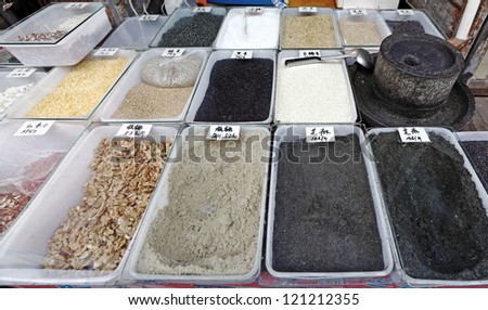Trays of exotic grounded herbs and sesame seed displayed in a street herbalist stall in ancient street market of Shantangjie in Suzhou city, China.