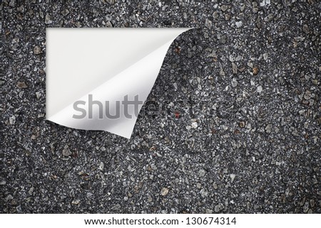 A black tarmac road surface peeling off at the edge with blank space for text.