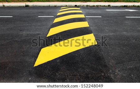 A yellow stripe speed ramp on an asphalt road.