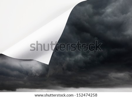 A stormy cloudy sky with a fold at the edge with blank space for text, for the concept of unfolding weather.