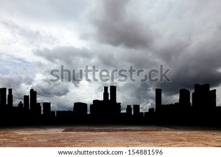 Silhouette of a city skyline in a dusty wasteland with a dark stormy raincloud in the horizon for the concept of urban wasteland.
