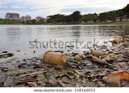 Discarded Plastic Debris Polluting A Waterway In An Urban Park.