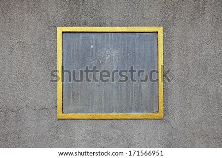 A golden picture frame border on a stone mason wall with blank space for text.