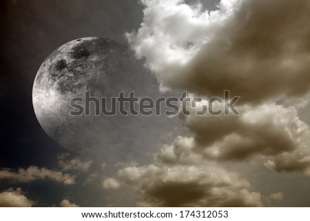 A full moon in a surreal cloudy night sky. Elements of this image furnished by NASA.