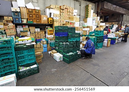 TOKYO - DECEMBER 24, 2014: A vendor inspects his goods in the Tsukiji Fish Market in Tokyo, Japan. The Tsukiji market is the biggest wholesale food market in the world.