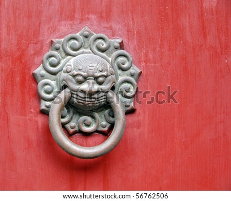 An image of an ancient door knob from a Chinese temple with a mythical lion motif.