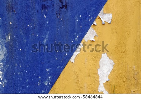 Two color, blue and yellow, peeling concrete wall as textural background.