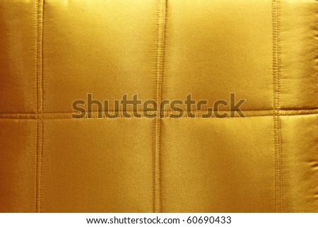 A gold colored silk pillow upholstery.