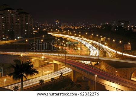 Trails of light left by vehicles on a intricate motor highway system at night.