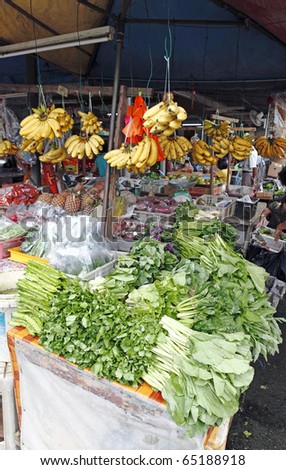 Fresh green leafy vegetables and fruits for sale at a rural countryside farmer\'s market.