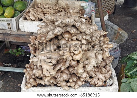 An image of fresh raw ginger roots for sale at a rural market stall.