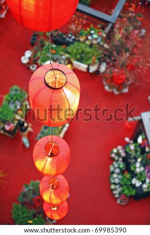 A row of red lantern hanging down into a floral bazaar.