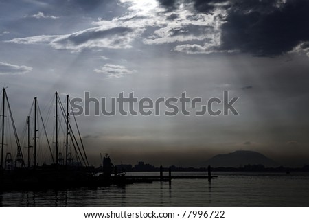 Silhouette of yacht docked on a coastal marina in Penang, Malaysia, at the break of day against a beautiful surreal sky.