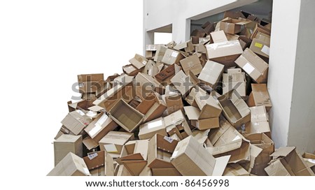 Discarded brown colored corrugated paper carton boxes overflowing from a recycle refuse chamber, isolated against white.
