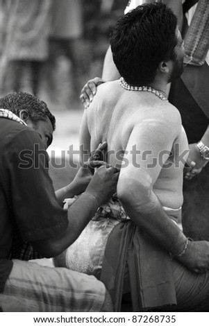 KUALA LUMPUR, MALAYSIA - JANUARY 20: A hindu devotee subjected to painful body piercing on Thaipusam festival on January 20, 2011 in Batu Cave as fulfillment of their vows made to Lord Murugan.