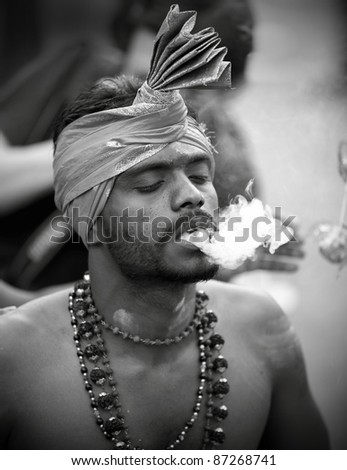 KUALA LUMPUR, MALAYSIA - JANUARY 20: Hindu devotee in traditional costume in a trance on Thaipusam on January 20, 2011 in Batu Cave to show devotion to Lord Murugan victory over the demon Soorapadman